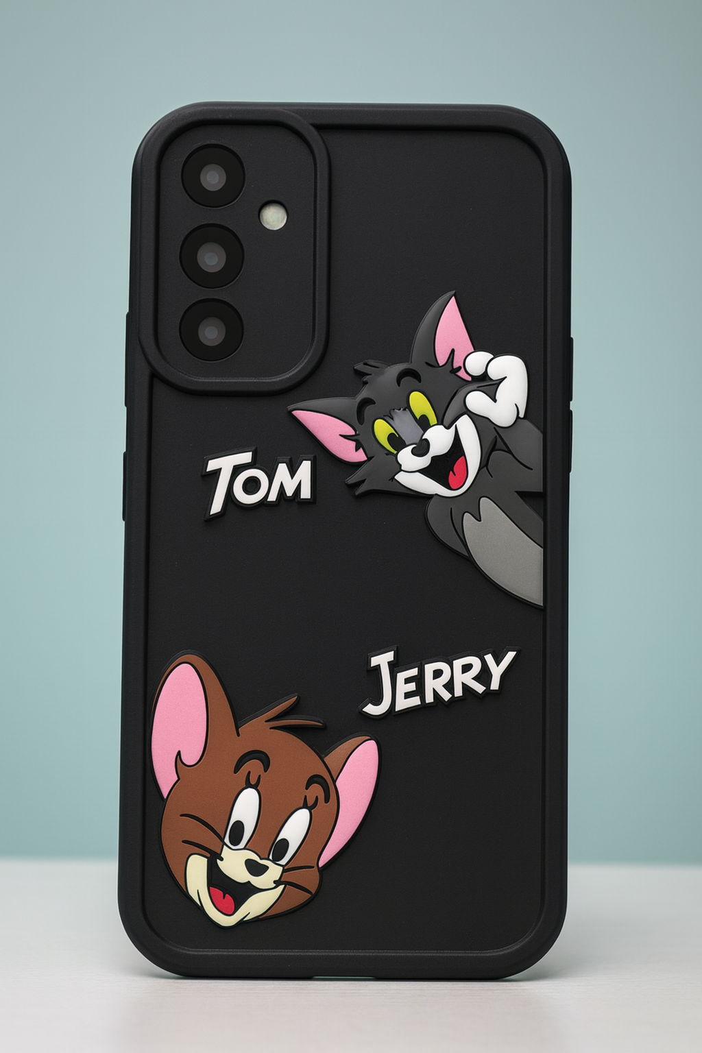 lack silicone phone case featuring 3D Tom & Jerry cartoon characters with a matte finish, displayed on a clean minimal background.